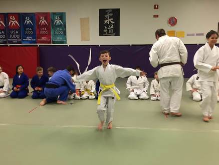 students seated in martial arts uniforms